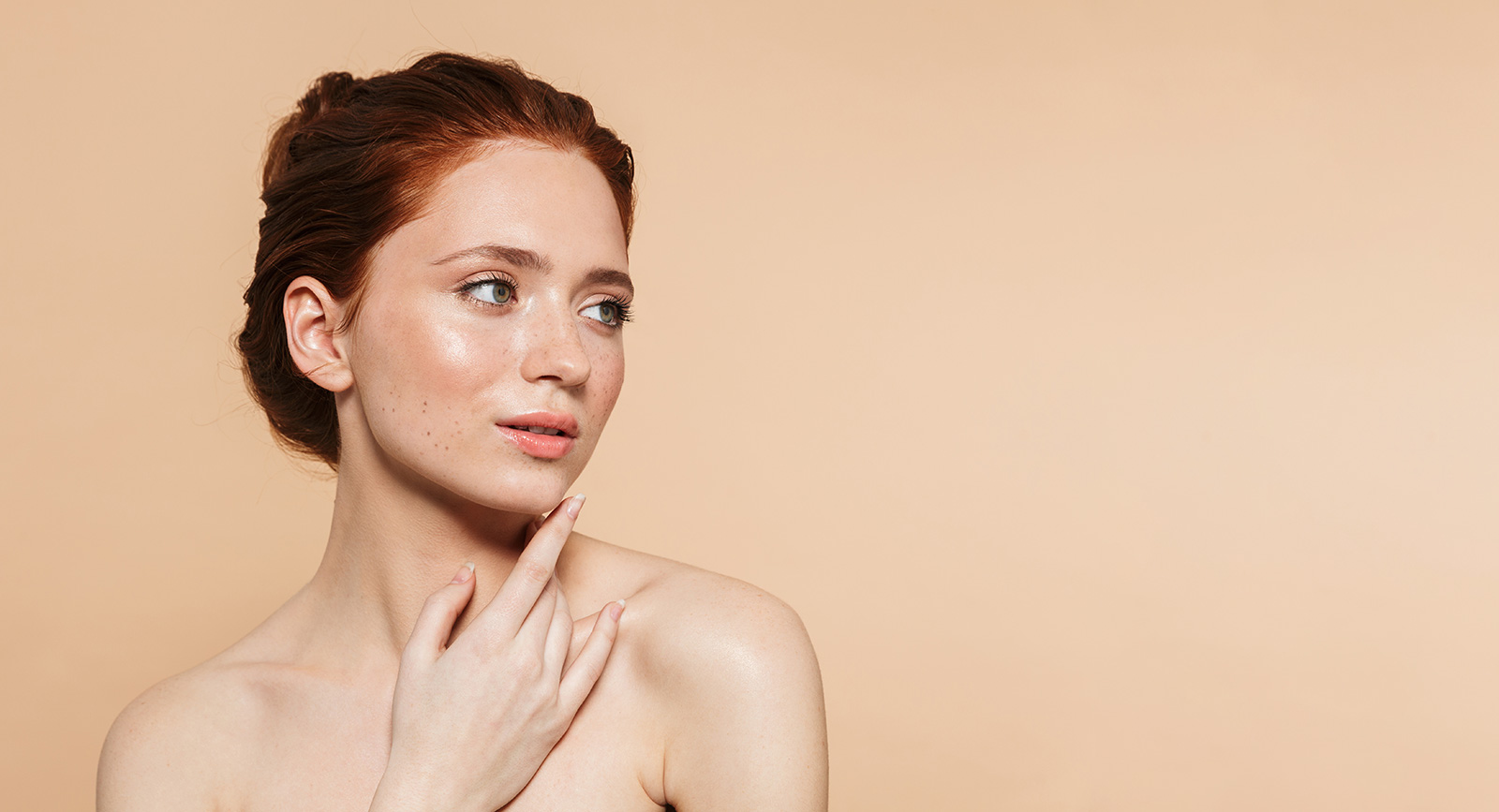 young-redhead-woman-posing-isolated-over-beige-wall-background.